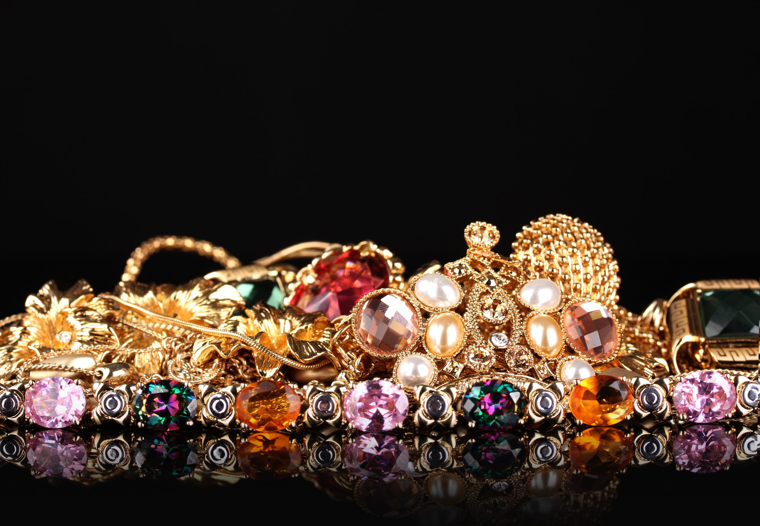 Various gold jewellery on black background gold karat